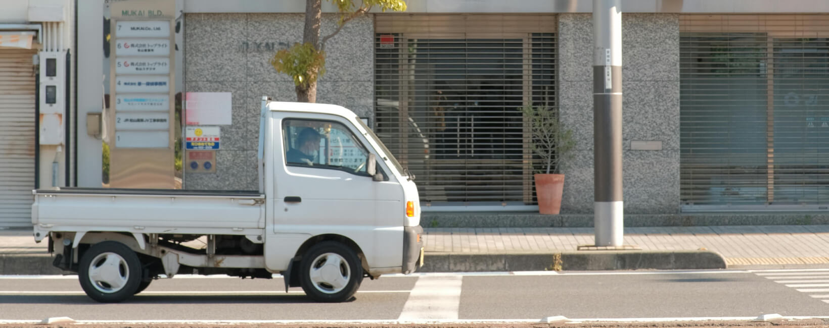 A DD51T Suzuki Carry parked on a Japanese street.
