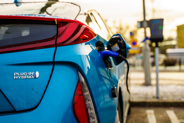 Blue Toyota Prius being charged at a public charging point - electric cars from japan